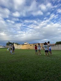 People playing on field against sky