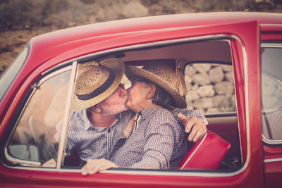 Senior couple kissing in vintage car