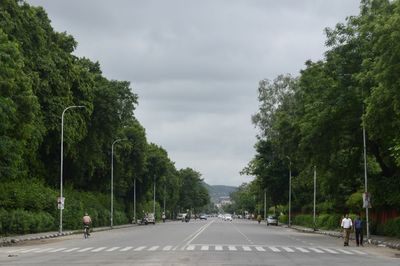 Street amidst trees against sky