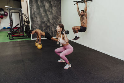 Sports people exercising with equipment in gym