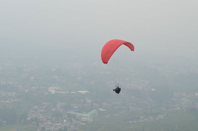 Person paragliding against sky