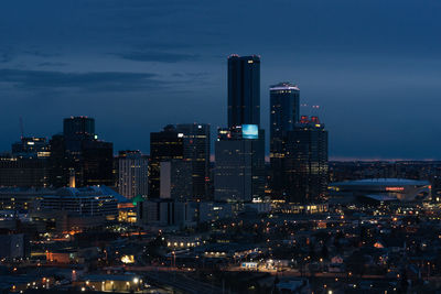 Illuminated buildings in city against sky at night