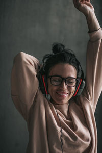 Portrait of smiling young woman against wall