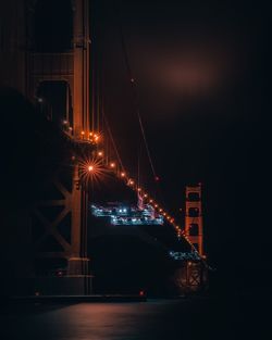 Illuminated bridge against sky at night