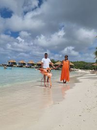 Full length of couple with flamingo at beach