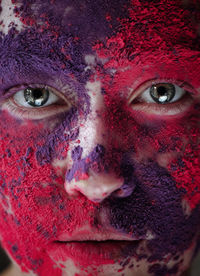 Close-up portrait of woman with multi colored powder paint