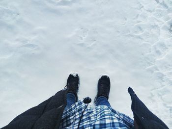Low section of man standing by water against sky