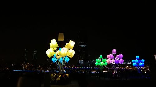 Illuminated ferris wheel in city at night