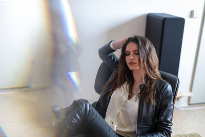 Young woman sitting on chair at home