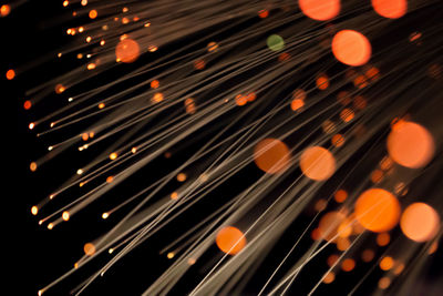 Close-up of illuminated fiber optic against black background