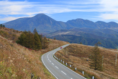 Road by mountains against sky