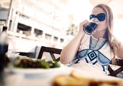 Woman drinking beer while resting at restaurant