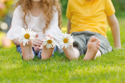 Little girl and boy with barefoot in summer park. 