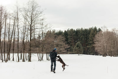 Man walking on snow covered field