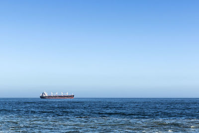 Sailboat sailing on sea against clear sky