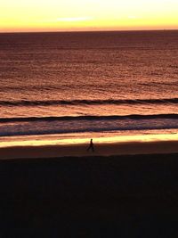 Silhouette of people on beach at sunset