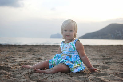 Portrait of little girl sitting at beach