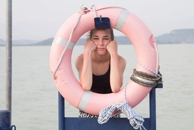 Portrait of woman with hands on cheek seen through inflatable ring