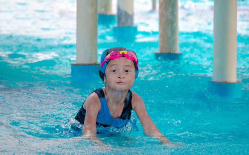 Cute girl standing in swimming pool