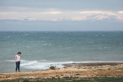 Rear view of woman standing on beach