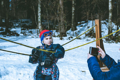 Cropped hand of mother photographing son