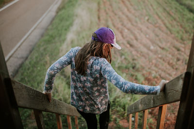 Rear view of woman holding steps railings