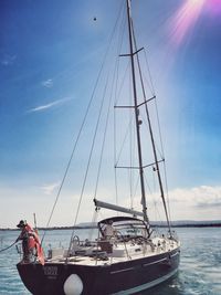 Man and woman on sailboat in sea against sky