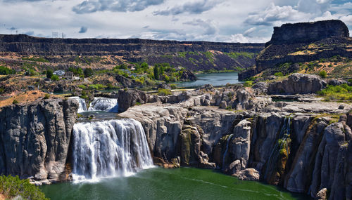 Scenic view of waterfall against sky