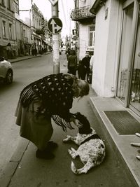 Full length of woman on footpath by street in city