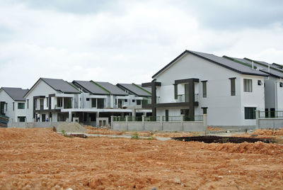 Houses on field against sky