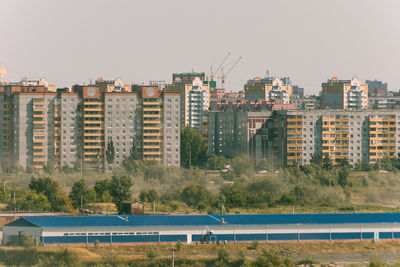 Buildings in city against clear sky