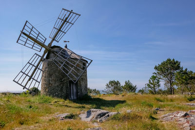 Traditional windmill on field against sky