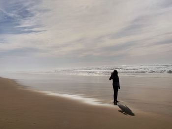 Full length of man walking on beach against sky