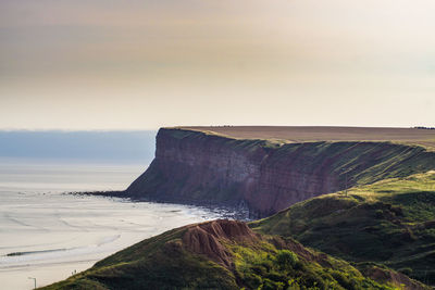 Scenic view of sea and mountains against sky