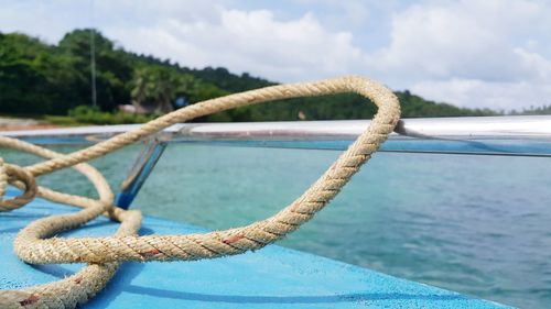 Close-up of rope tied to swimming pool against sea