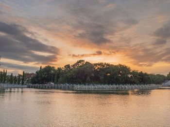 Scenic view of river against sky at sunset