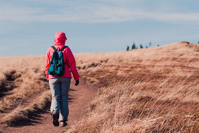 Rear view of woman walking on field