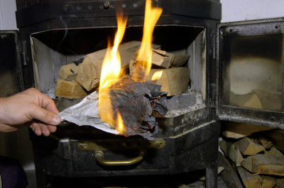 Person holding burning candles on log