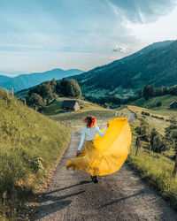 Rear view of woman on field against sky