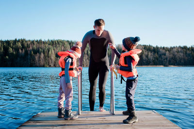 Father going cold water swimming whilst at the beach with his kids