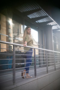 Portrait of woman walking by railing