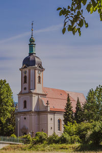 View of building and trees against sky