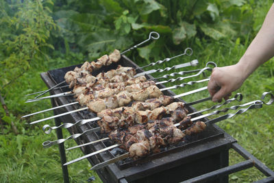 Cropped image of person preparing food on barbecue grill