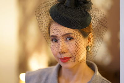 Portrait of woman wearing veiled hat 