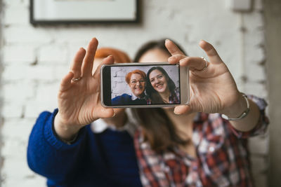 Selfie of smiling adult daughter with mother