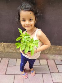 Portrait of young firl holding plant