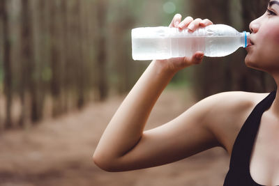 Cropped image of thirsty woman drinking water