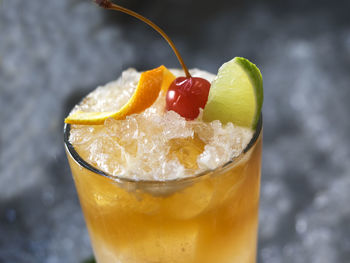 Close-up of drink garnish with bell pepper and herb in glass on crushed ice