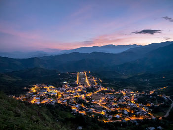 Aerial view of illuminated buildings against sky at sunset