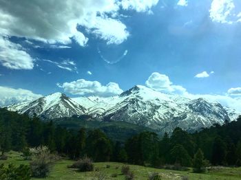 Scenic view of snowcapped mountains against cloudy sky